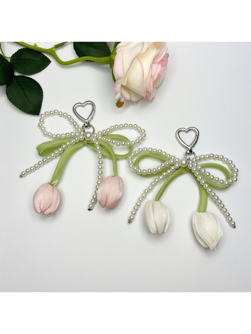 Minimalist bow and tulip pendant keychain on a white background