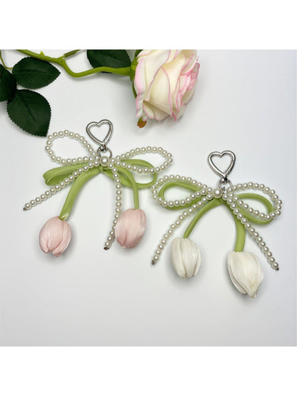 Minimalist bow and tulip pendant keychain on a white background