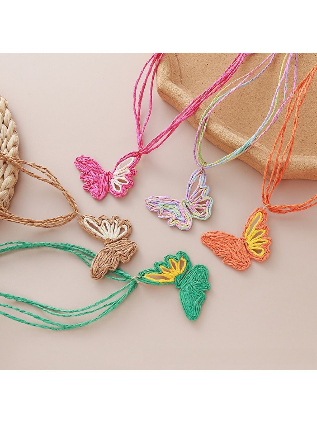 Earedge raffia butterfly pendant necklace on a white background