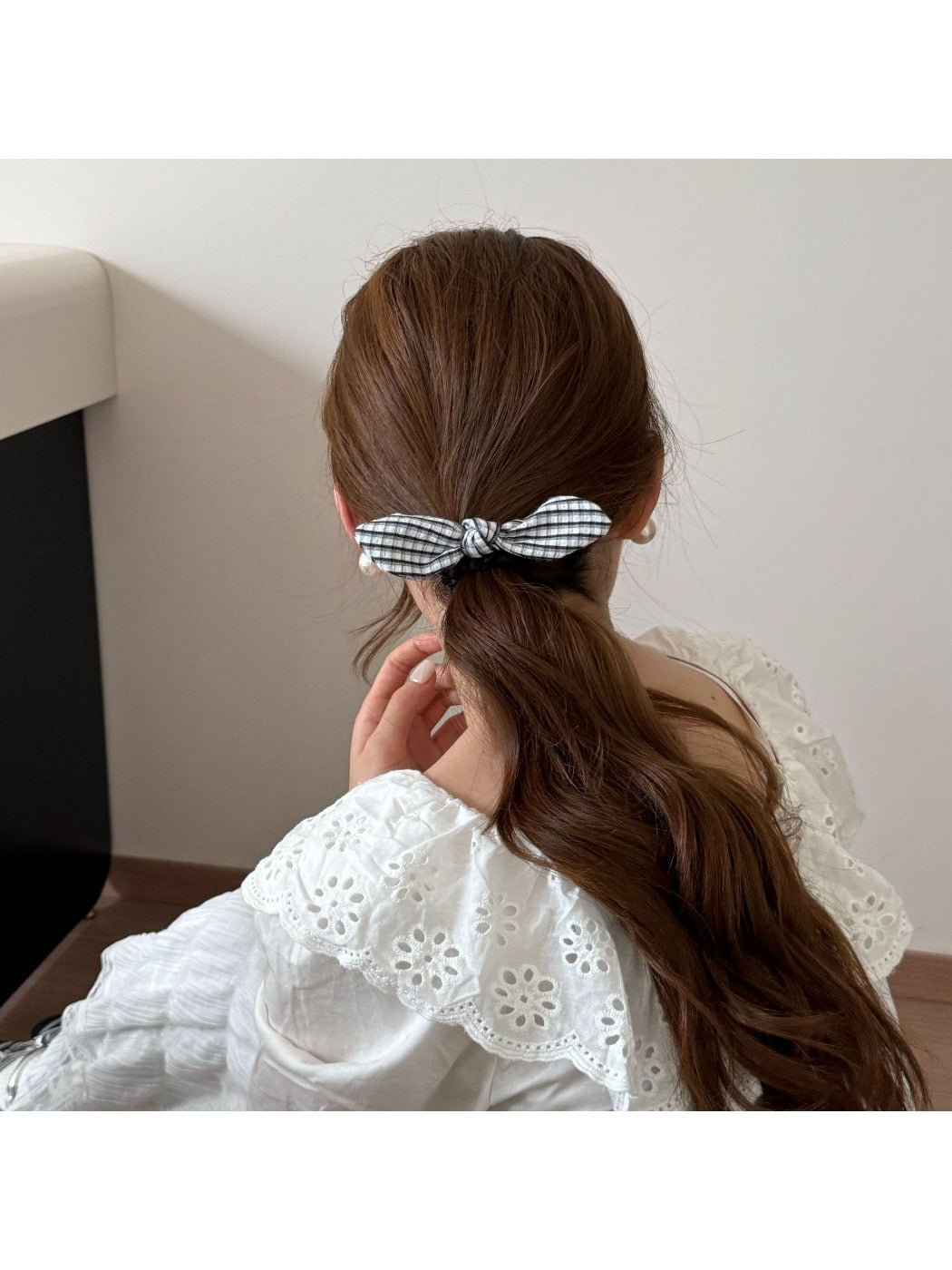 Gifty hair tie with plaid pattern and red bow displayed on a wooden table