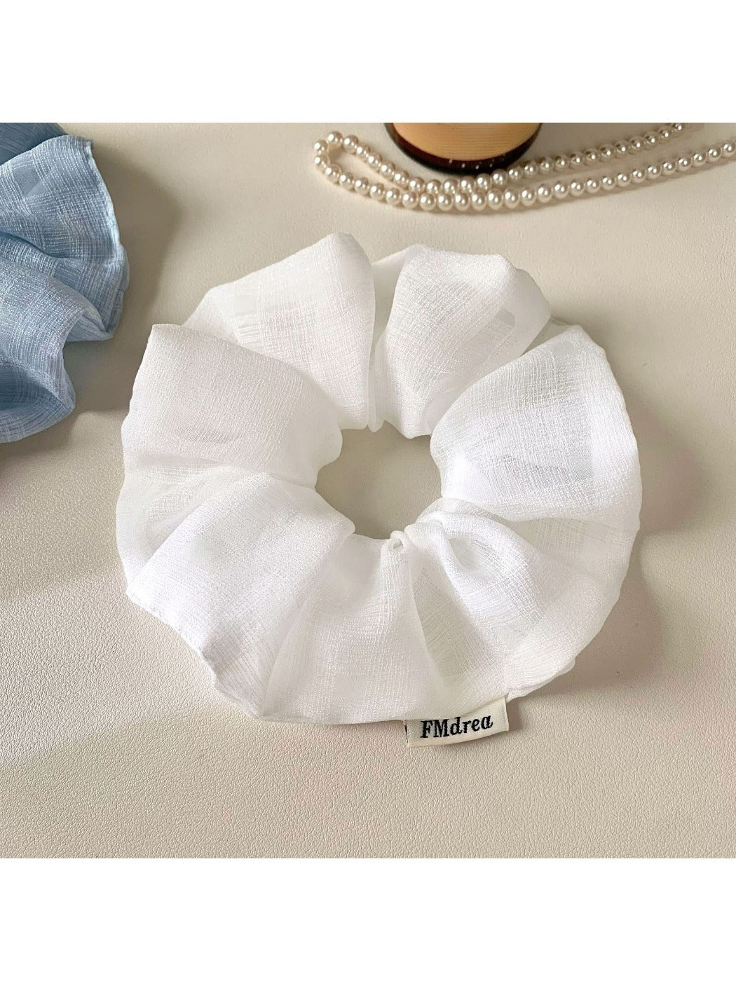 Model wearing a minimalist solid color ruched scrunchie in a ponytail