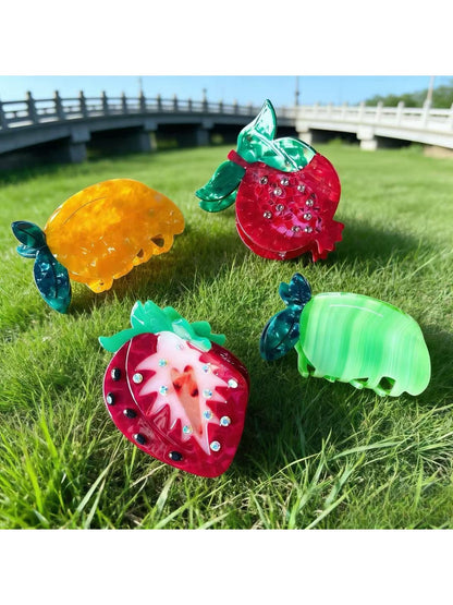 Beau acetate claw clip shaped like a red strawberry fruit with green leaves