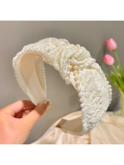 Black headband featuring a stylish bow decorated with small pearls and crystals