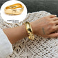 Lovra silver wide fit bracelet resting on a neutral fabric background