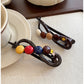 Close-up of Beau hair clip showing round colorful beads on gold metal bar