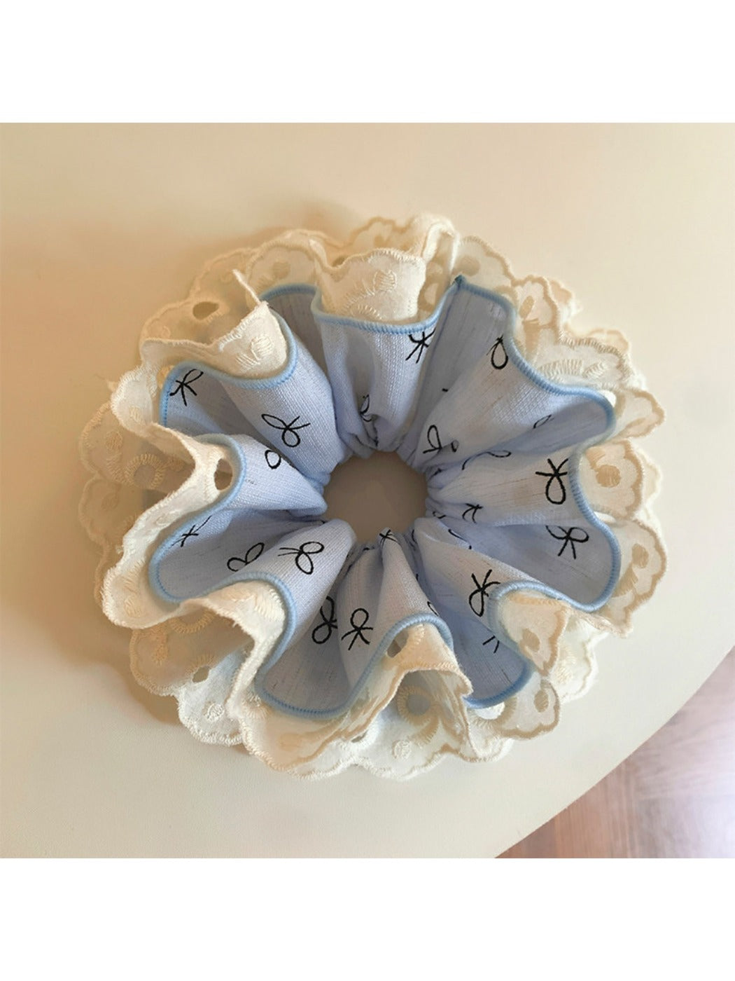 Gifty bow print ruffled scrunchie packaged in a clear plastic bag with branding