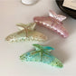 Close-up of the crescent-shaped hair claw clip showing vibrant multicolor design