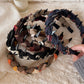 Close-up of Gifty knitted fabric wrapped headband in beige color
