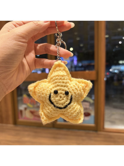 Multiple yarn star keychains in different colors arranged in a row