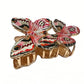 Red butterfly hair clip attached to brown hair showing size and shape