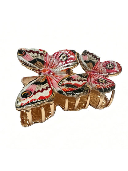 Red butterfly hair clip attached to brown hair showing size and shape