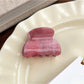 Beau pink ombre hair claw clip placed on wooden surface with natural light