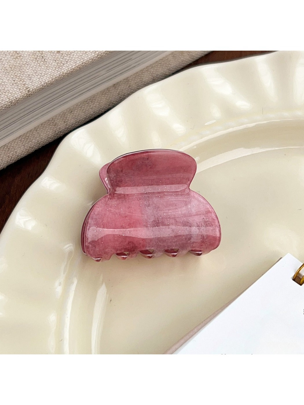 Beau pink ombre hair claw clip placed on wooden surface with natural light