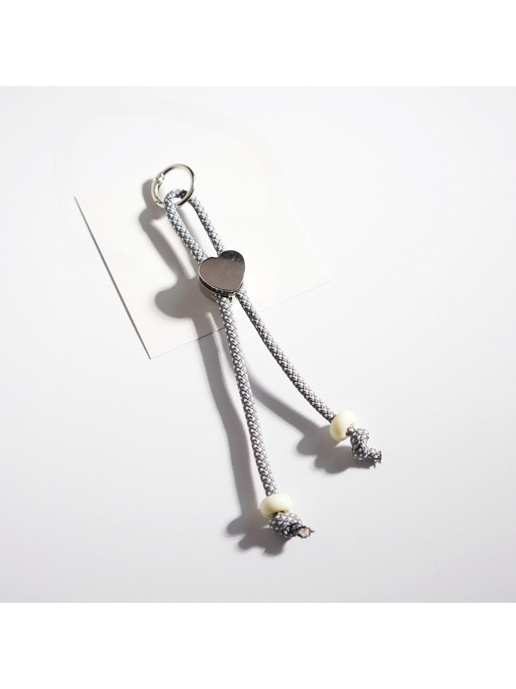 Colorful rope heart keychain displayed on a flat surface with soft lighting