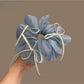 Close-up of blue ribbon bow tulle scrunchie on white background