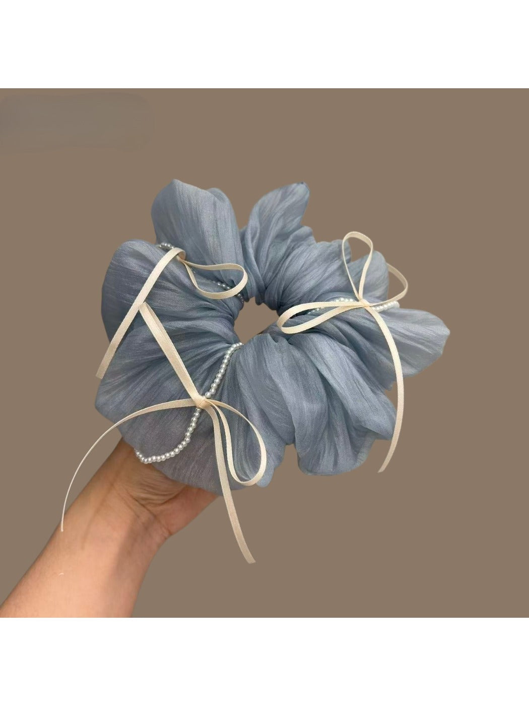 Close-up of blue ribbon bow tulle scrunchie on white background