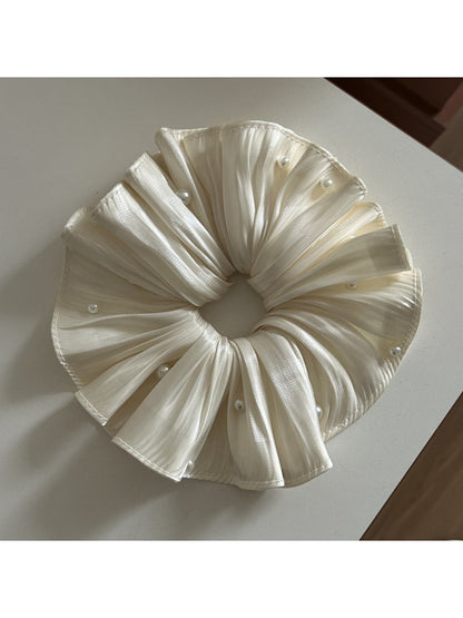 Side view of the satin scrunchie highlighting its gathered design