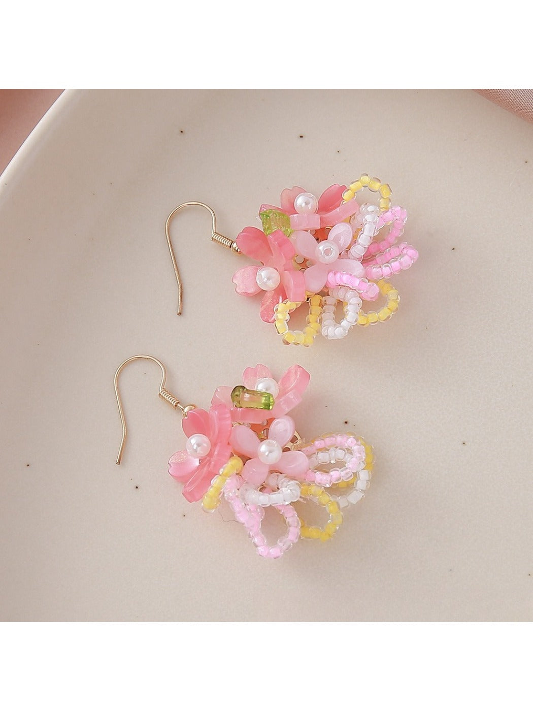 Pair of colorful flower cluster earrings displayed on a wooden surface