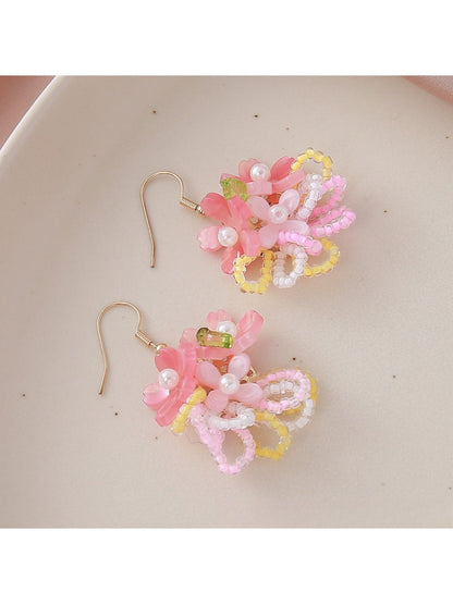 Pair of colorful flower cluster earrings displayed on a wooden surface