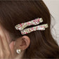 Beau hair clip worn in styled hair, displaying floral design and size