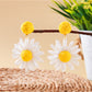 Side view of raffia stud earring showing woven daisy flower design