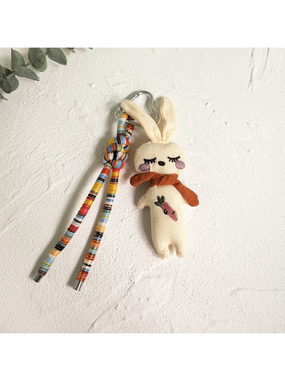 Vintage rabbit charm keychain placed next to a small notebook and pen