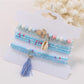 Lovra stackable bracelet displayed on white background showing tassel and bead design
