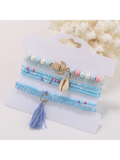 Lovra stackable bracelet displayed on white background showing tassel and bead design