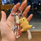 Bear keychain hanging from a backpack zipper pull in a casual setting