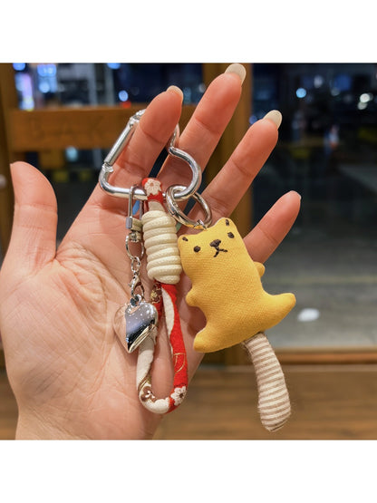 Bear keychain hanging from a backpack zipper pull in a casual setting