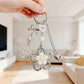 Close-up of delicate flower charm on minimalist keychain with silver keyring