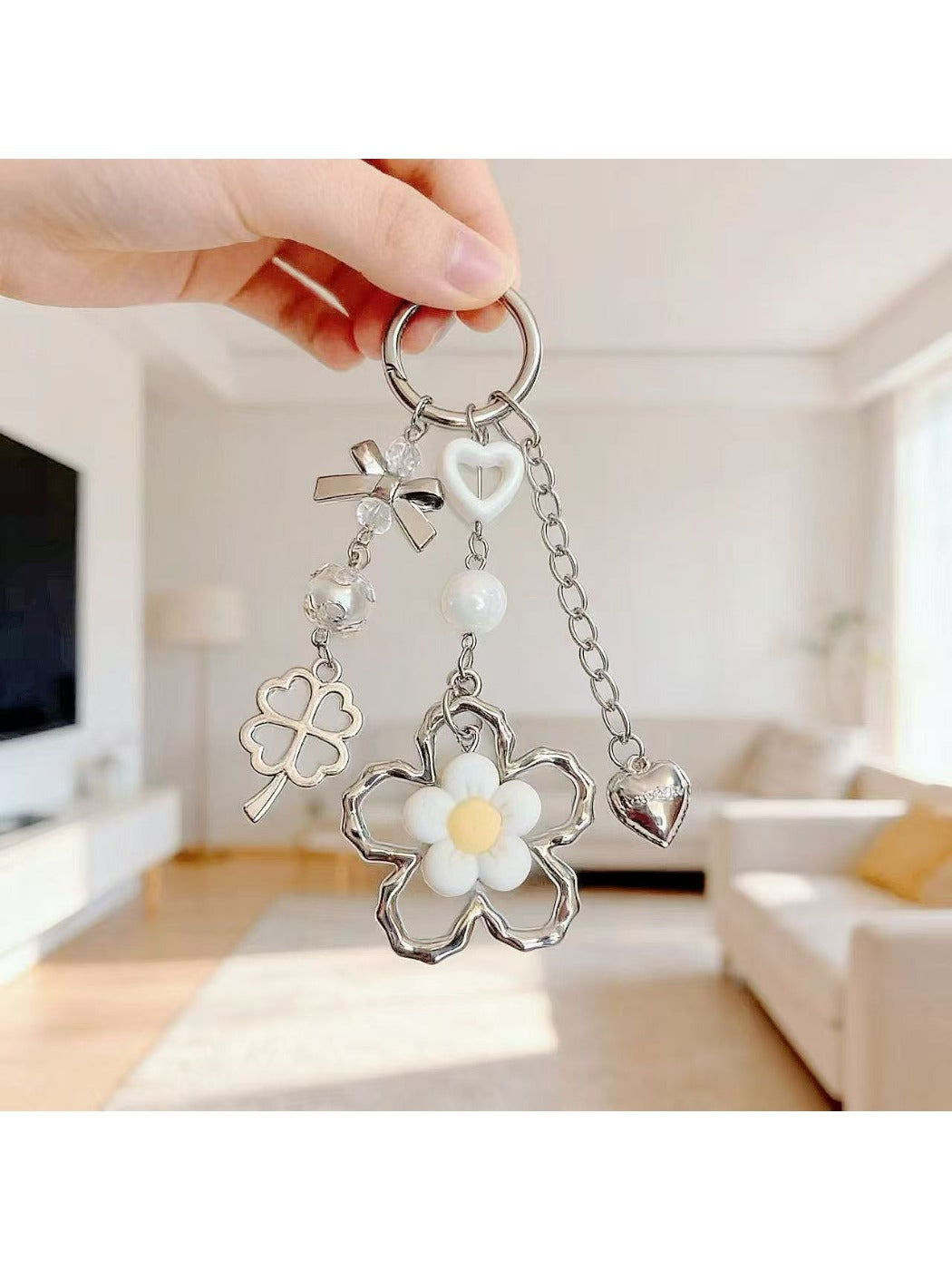 Close-up of delicate flower charm on minimalist keychain with silver keyring
