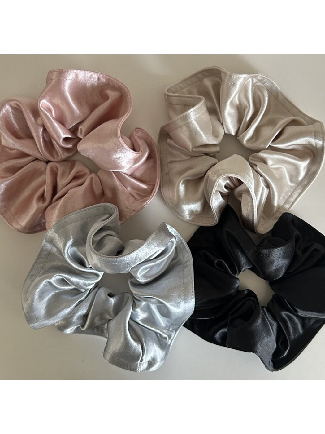 Top view of Gifty satin scrunchie showing smooth, shiny fabric texture
