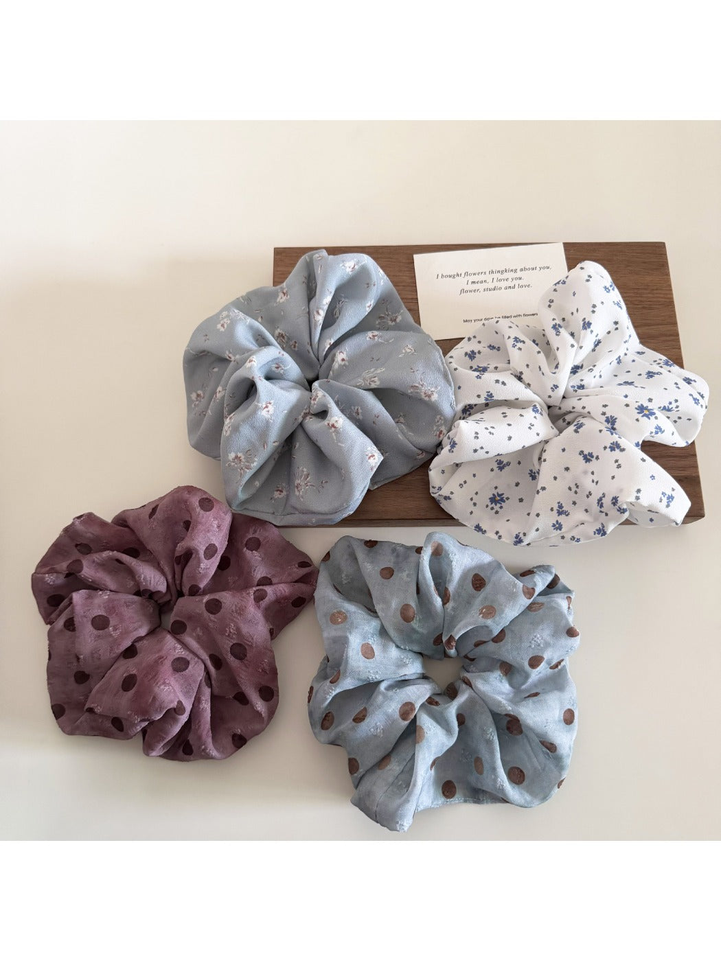 Close-up of Gifty scrunchie showing detailed floral and polka dot design