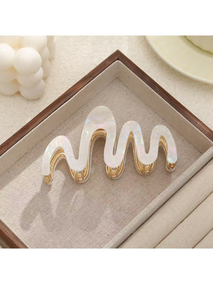 Beau wavy hair clip in silver finish displayed against a dark background
