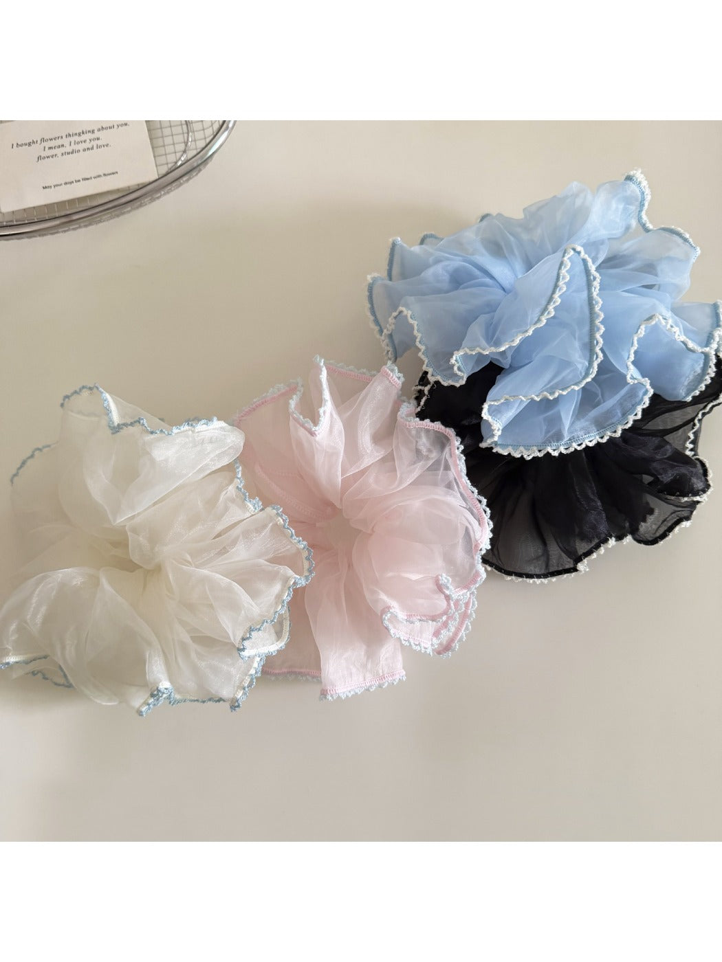 Gifty ruffled scrunchie worn on a wrist showing its texture and color