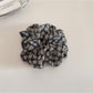 Gifty scrunchie wrapped around ponytail highlighting floral design