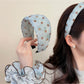 Matching blue scrunchie with white polka dots on a plain white surface