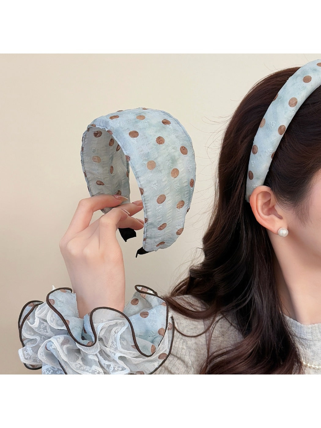 Matching blue scrunchie with white polka dots on a plain white surface
