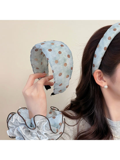 Matching blue scrunchie with white polka dots on a plain white surface