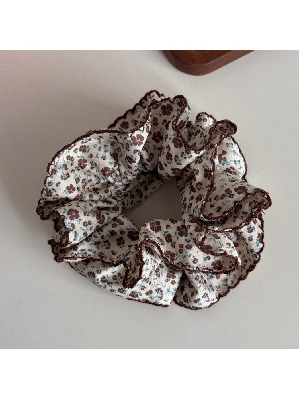 Flat lay of Gifty Retro Lace Floral Scrunchie alongside matching accessories on beige cloth