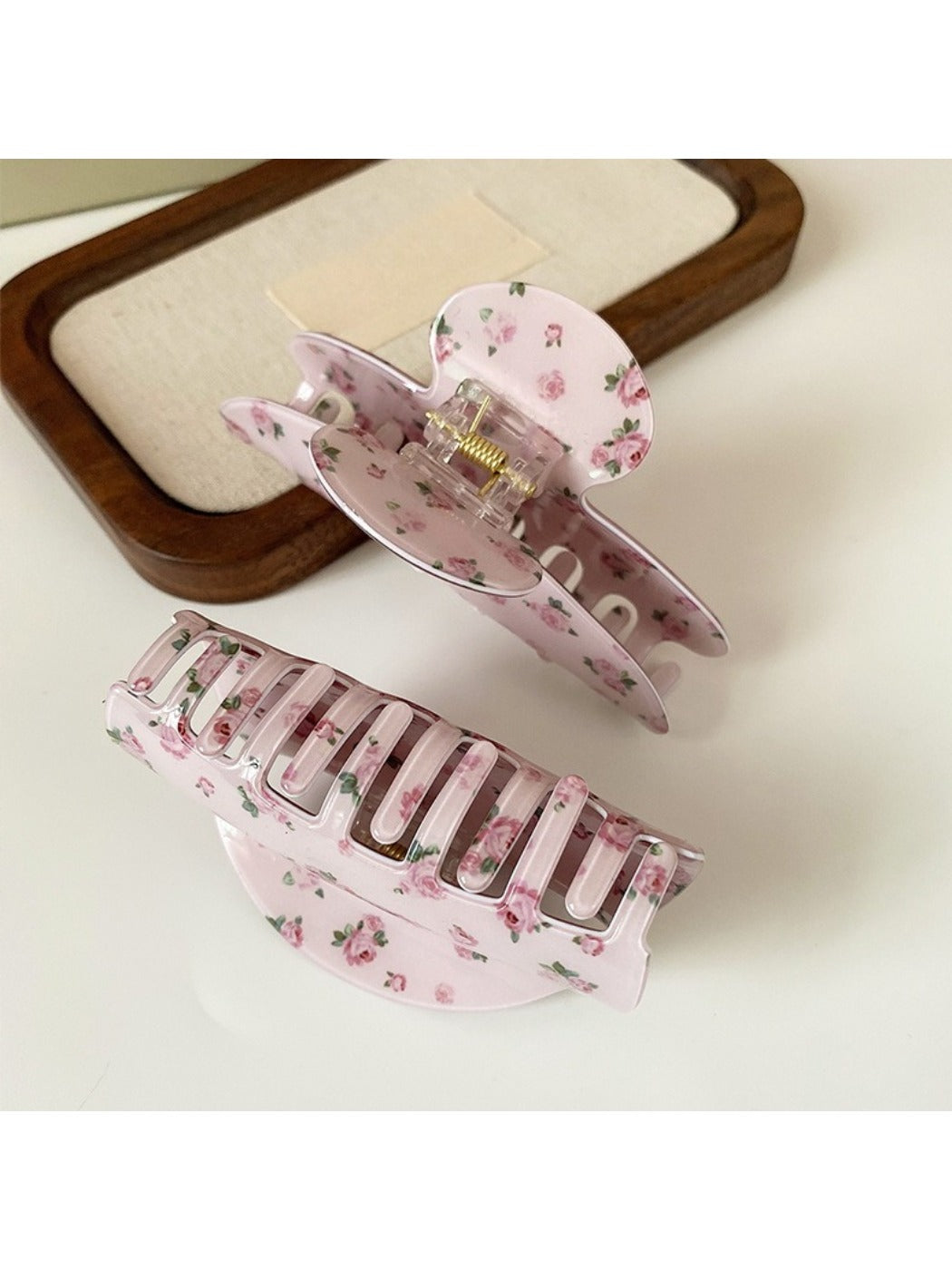 Beau hair claw clip held in hand showing size and rose print details