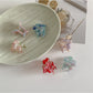 Beau small flower claw clip held in hand displaying size and shape