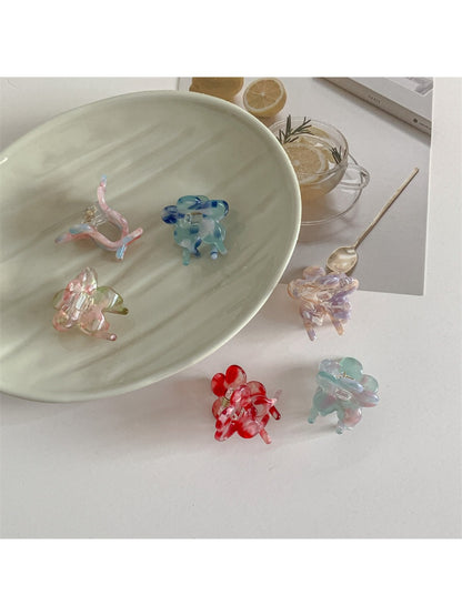 Beau small flower claw clip held in hand displaying size and shape