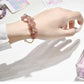 Close-up of Lovra crystal charm bracelet showing detailed charms