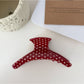 Beau acetate hair clip resting on white surface showing curved design