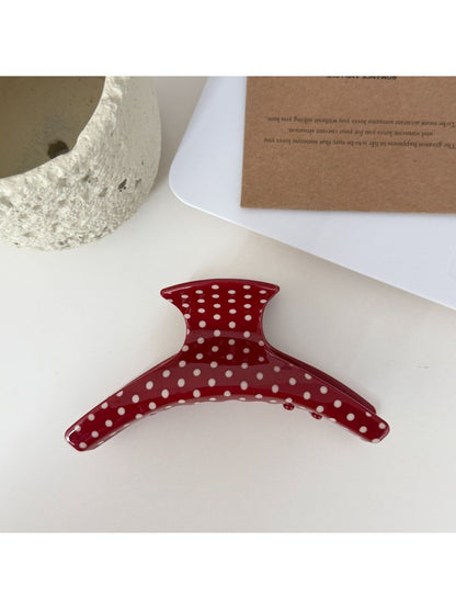 Beau acetate hair clip resting on white surface showing curved design