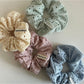 Close-up of beige scrunchie fabric showing delicate dot cutout pattern