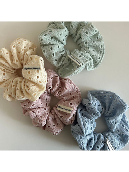Close-up of beige scrunchie fabric showing delicate dot cutout pattern