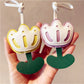 Tulip-shaped keychain hanging from a black backpack zipper